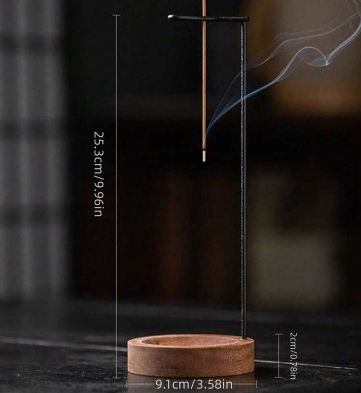 Incense stick holder with incense burning on a dark background