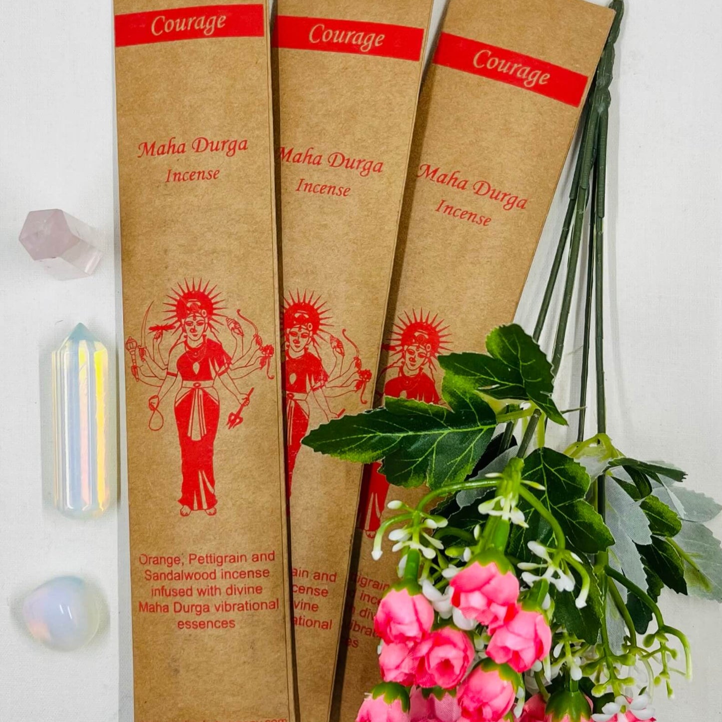 A packet of incense sticks with a printed女神MaháDüríça figure, alongside decorative flowers and leaves.