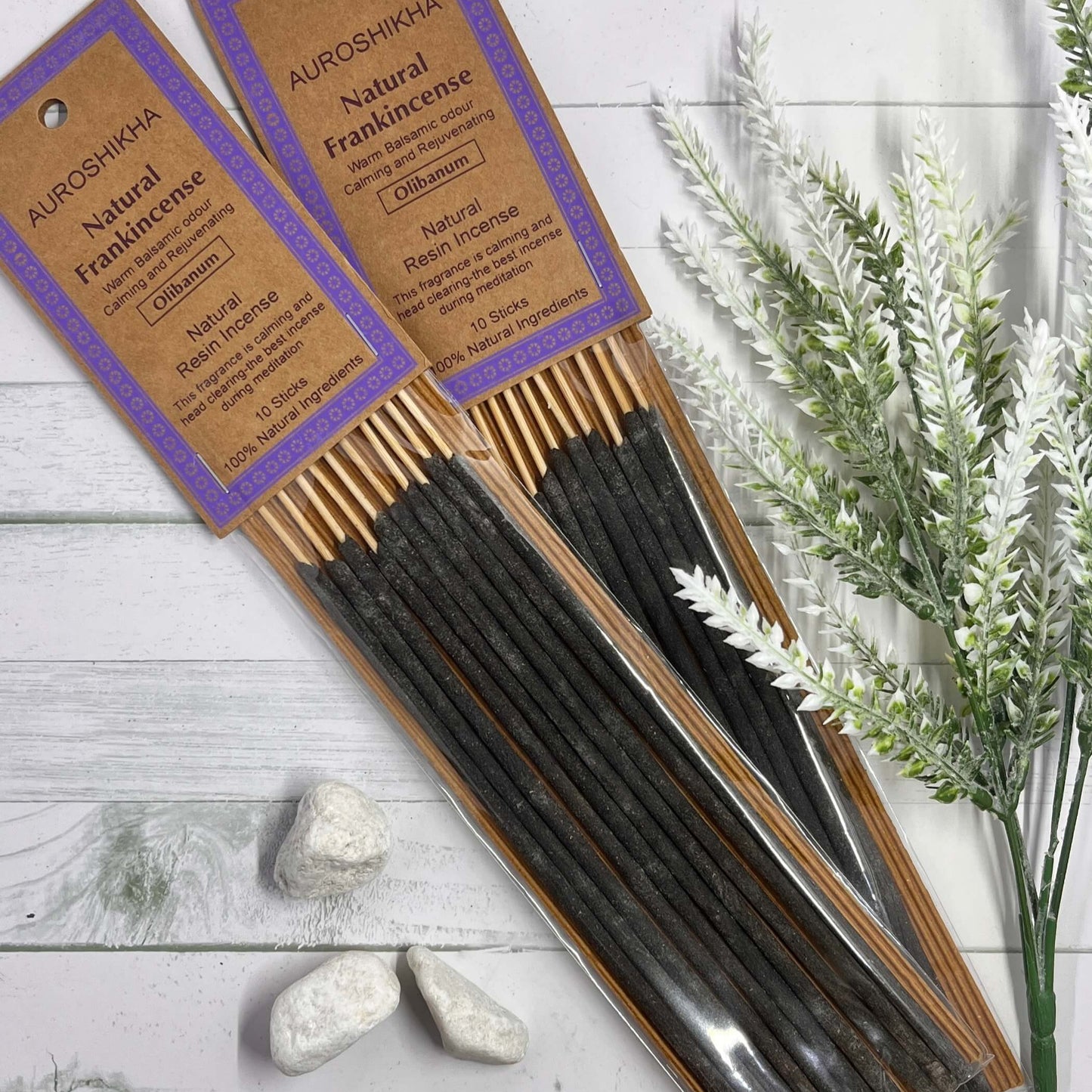 Packaging of Auroshikha Natural Resin Frankincense Incense with incense sticks displayed in front of a white background, accompanied by decorative herbs.