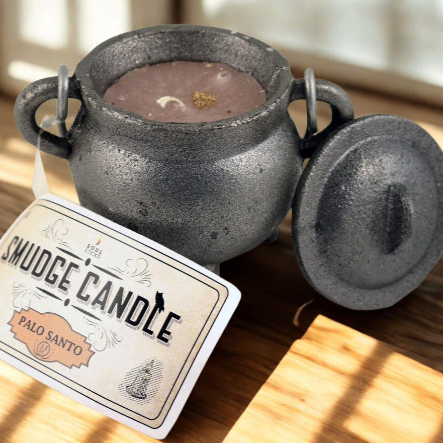 Smudge candle in a black pot with a label on a wooden surface