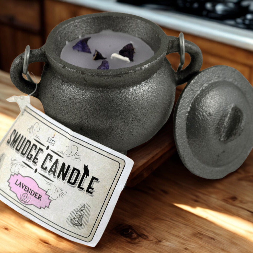 Smudge candle in a cast iron pot with a label on a wooden surface