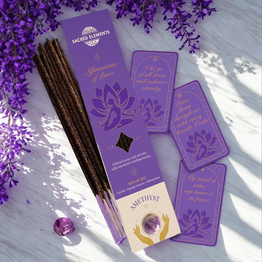 Purple ritual kit with incense sticks, cards, and amethyst crystal on a wooden surface with lavender flowers.