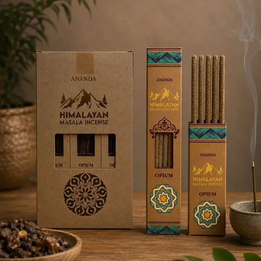 Three boxes of Ananda Himalayan Masala Incense in Opium scent, displayed on a wooden table with a burning incense stick, a bowl of spices, and green leaves in a warm, styled setting.