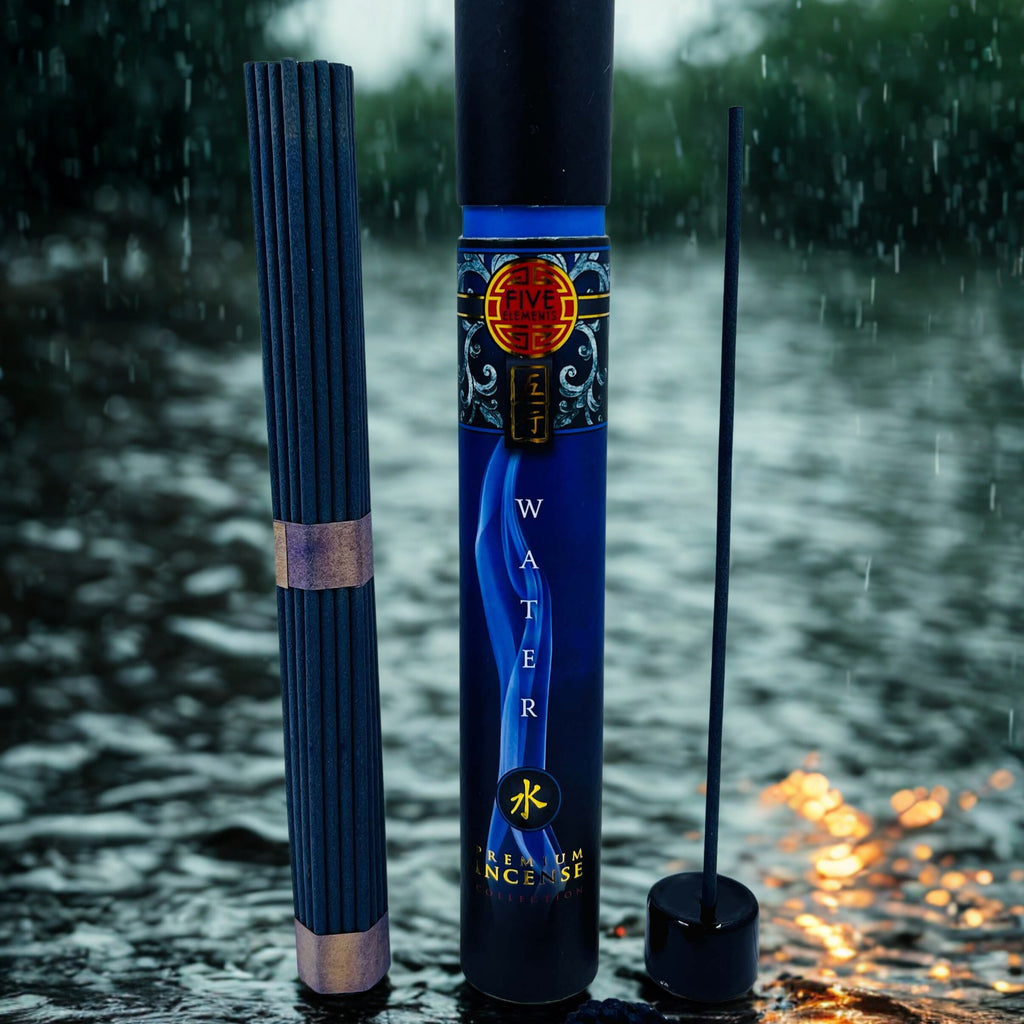 Incense stick and its packaging on a reflective water surface with raindrops.
