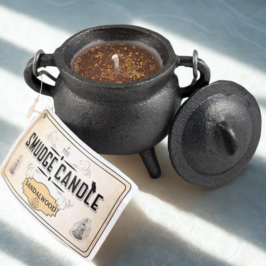 Smudge candle in a black ceramic container with a label on a light background