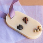 White chocolate bar with spices and a purple ribbon on a light purple background