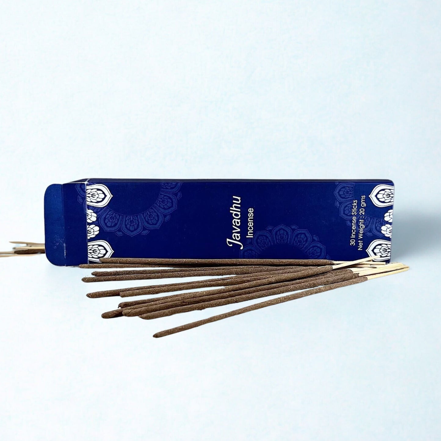 Incense sticks with a blue Javadek packaging on a light gray background