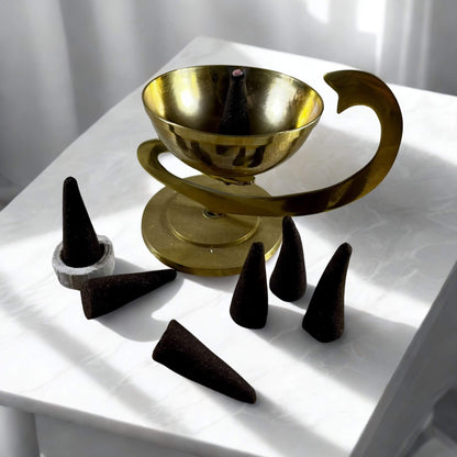 Gold bowl with black cones on a white surface