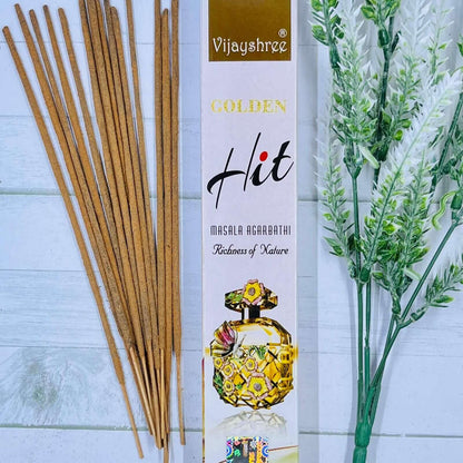 A pack of Vijayshree Golden Hit incense sticks displayed alongside a decorative item, with the product packaging visible in the background.
