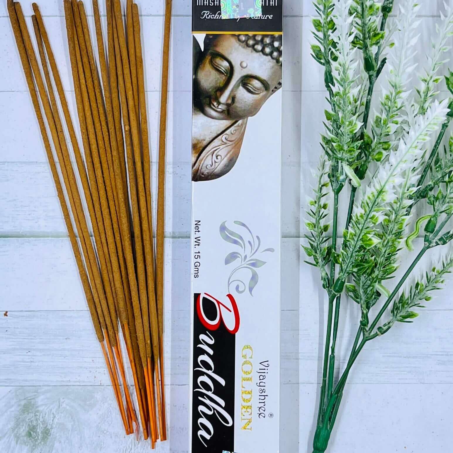 Incense sticks with a Buddha-themed packaging on a light wooden surface.