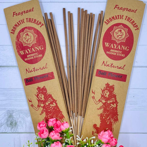 A packet of incense sticks branded 'WAYANG' with natural floral incense, displayed with pink flowers in the foreground.