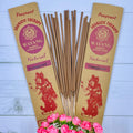 A packet of Balinese Frangipani incense sticks displayed alongside a bouquet of pink roses, with packaging featuring traditional Balinese artwork.