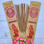 A packet of Balinese Frangipani incense sticks displayed alongside a bouquet of pink roses, with packaging featuring traditional Balinese artwork.