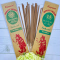 A packet of Balinese Coconut Incense with 20 sticks, displayed alongside a decorative flower arrangement. The packaging features a red traditional Bali figure illustration with 'Natural Coconut' written below.