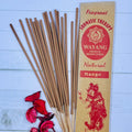 A packet of Balinese Mango incense sticks with 20 sticks displayed in front of the packet. There are also some dried flowers next to the incense sticks.