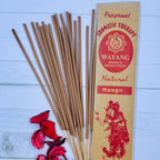 A packet of Balinese Mango incense sticks with 20 sticks displayed in front of the packet. There are also some dried flowers next to the incense sticks.
