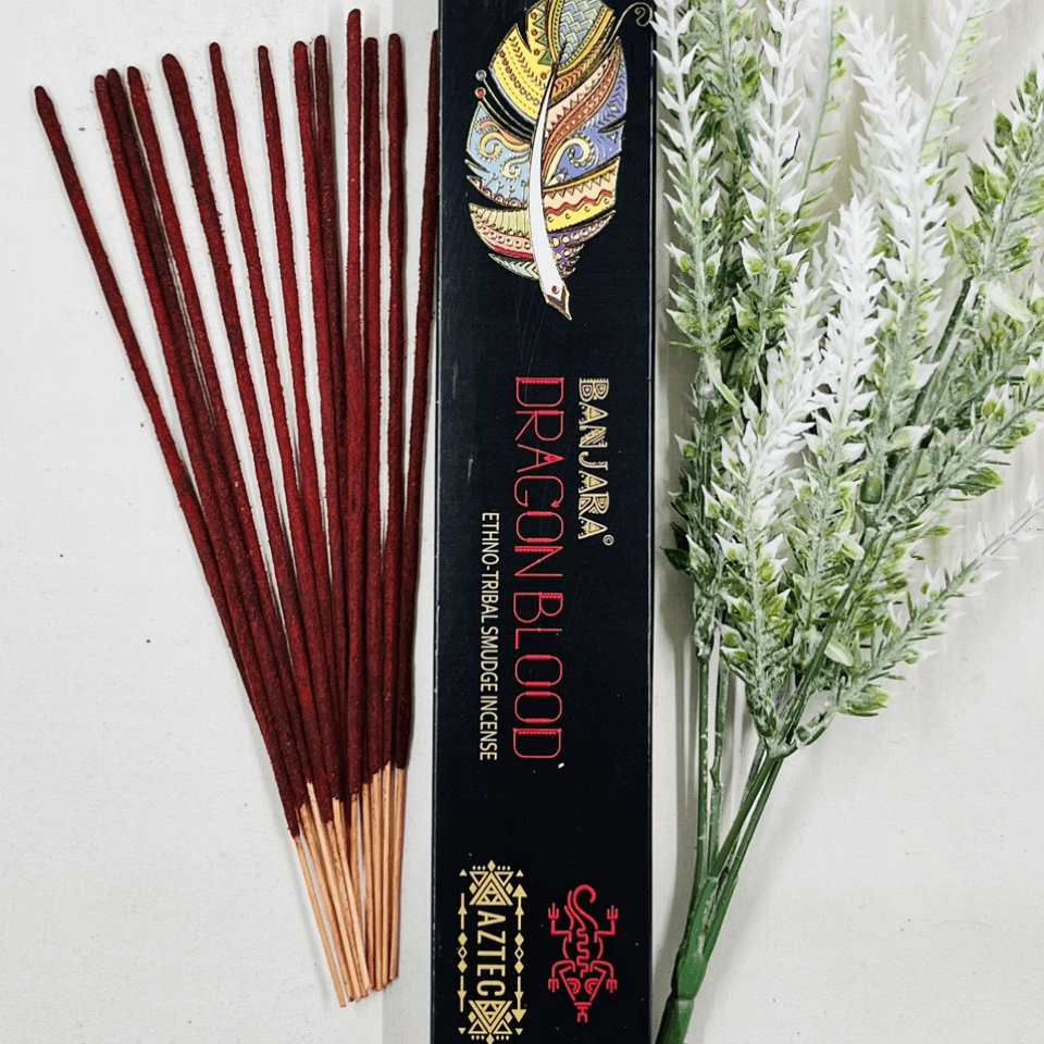 A packet of Banjara Aztec incense sticks with Dragons Blood fragrance, displayed alongside decorative foliage.