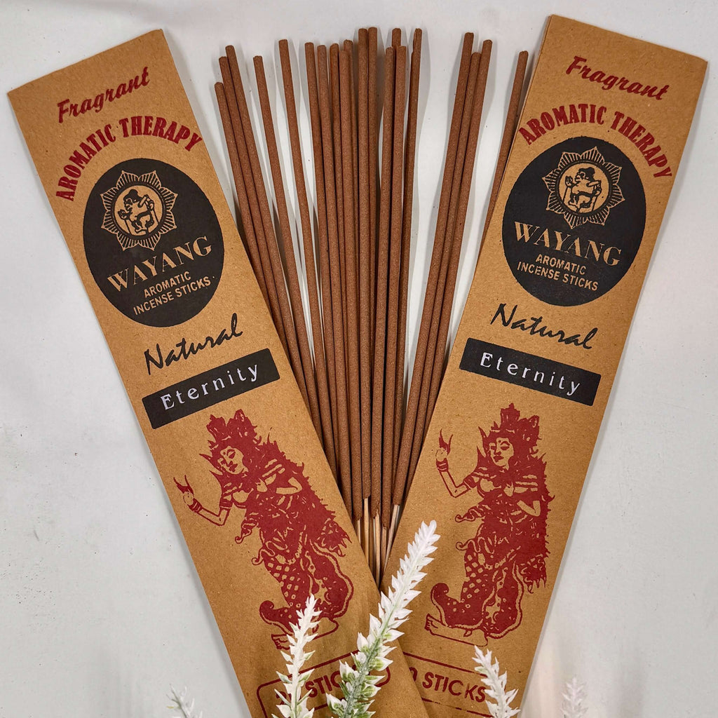 A bundle of Balinese Eternity incense sticks with brown packaging that has red and white text, and a decorative element in the background.