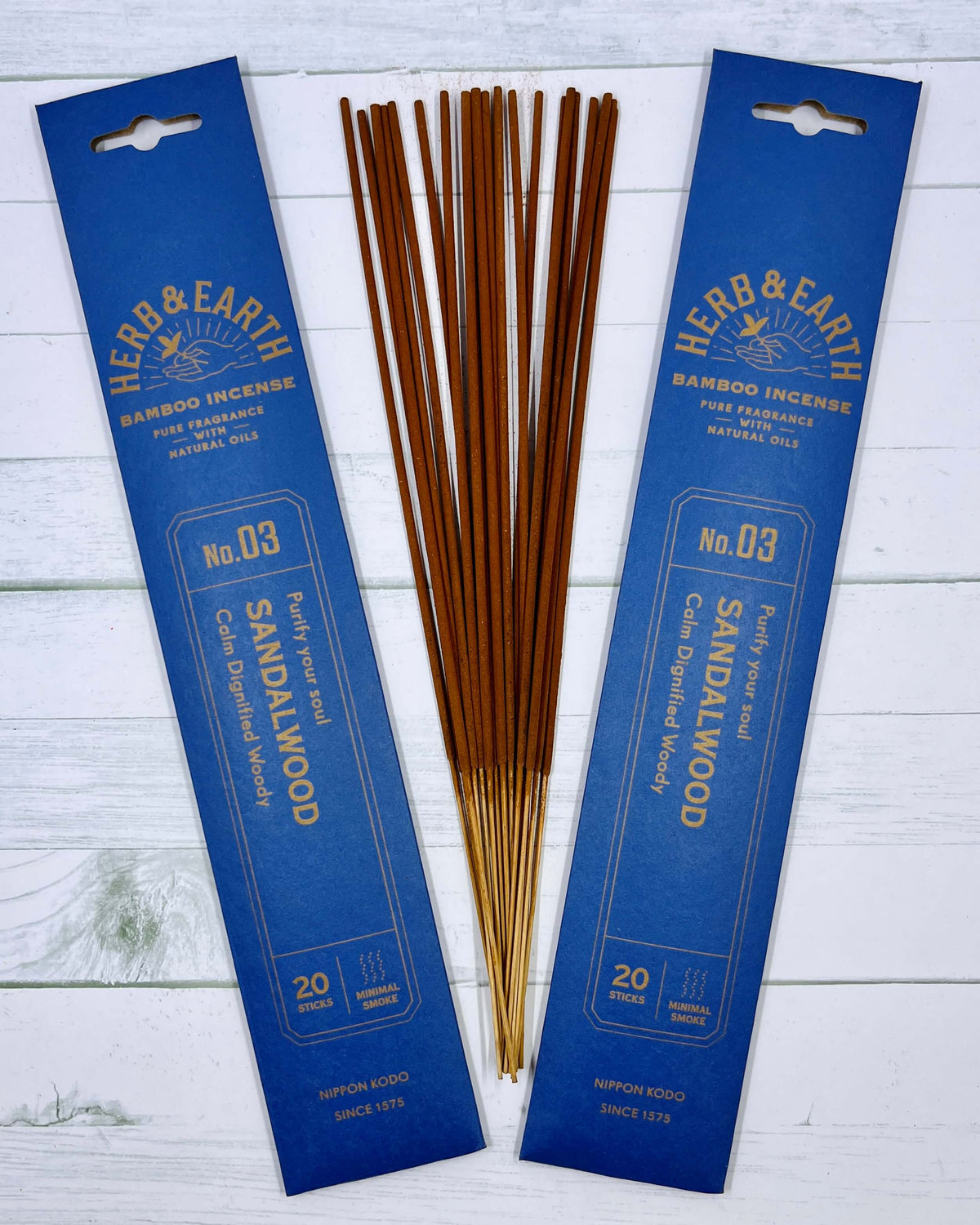 A packet of Herb & Earth bamboo incense sticks with sandalwood fragrance displayed on a wooden surface.