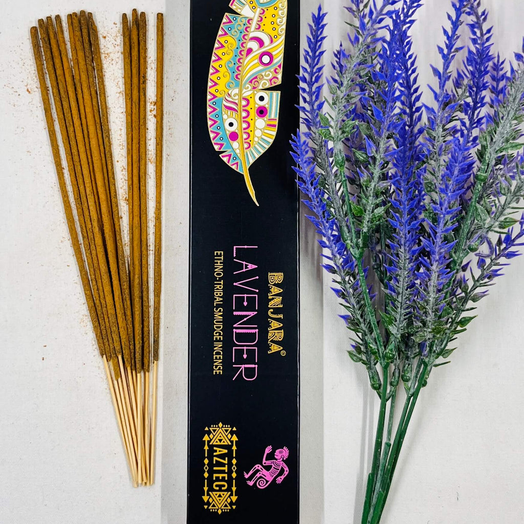 A packet of Banjara Aztec incense sticks with lavender color displayed next to a sprig of lavender.