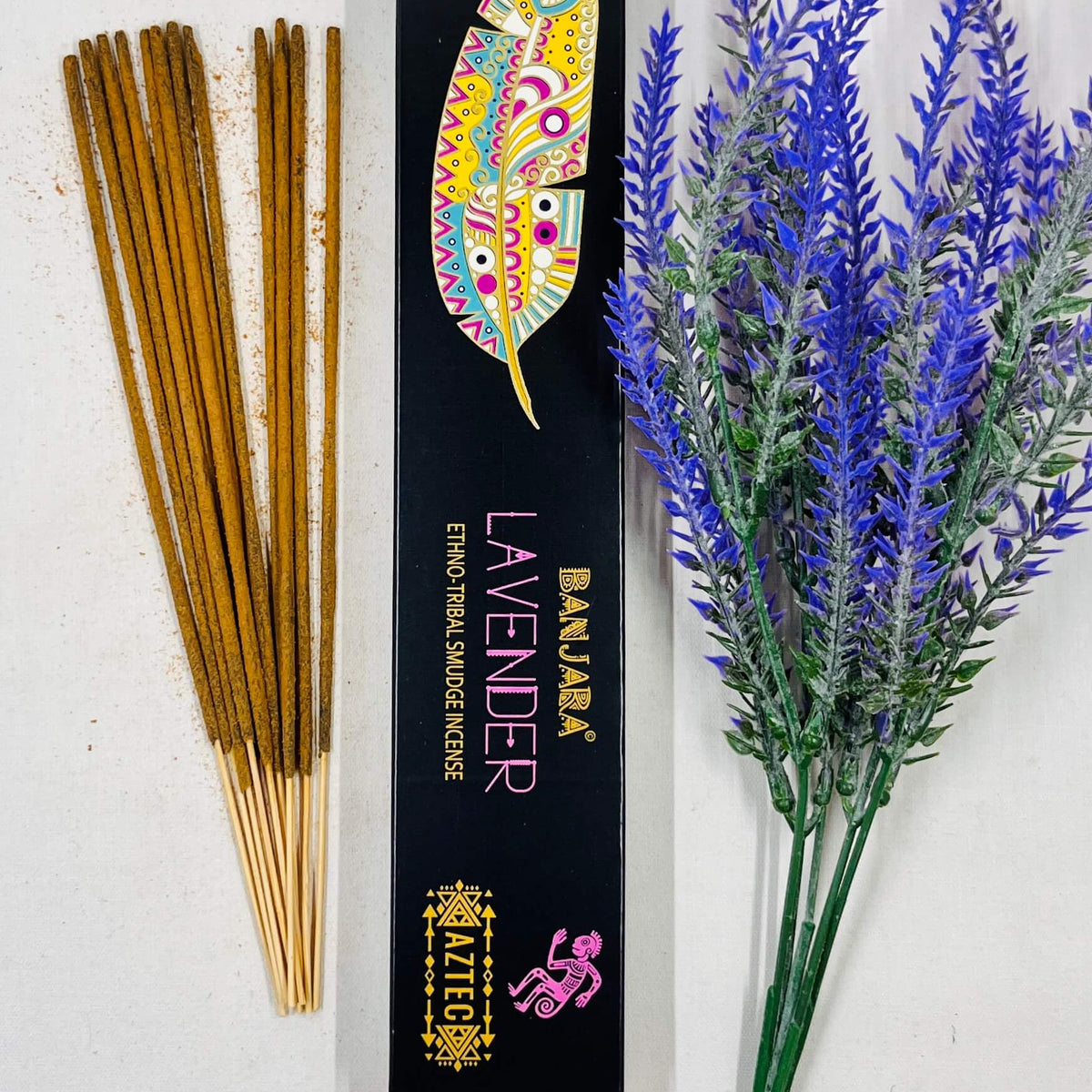 A packet of Banjara Aztec incense sticks with lavender color displayed next to a sprig of lavender.