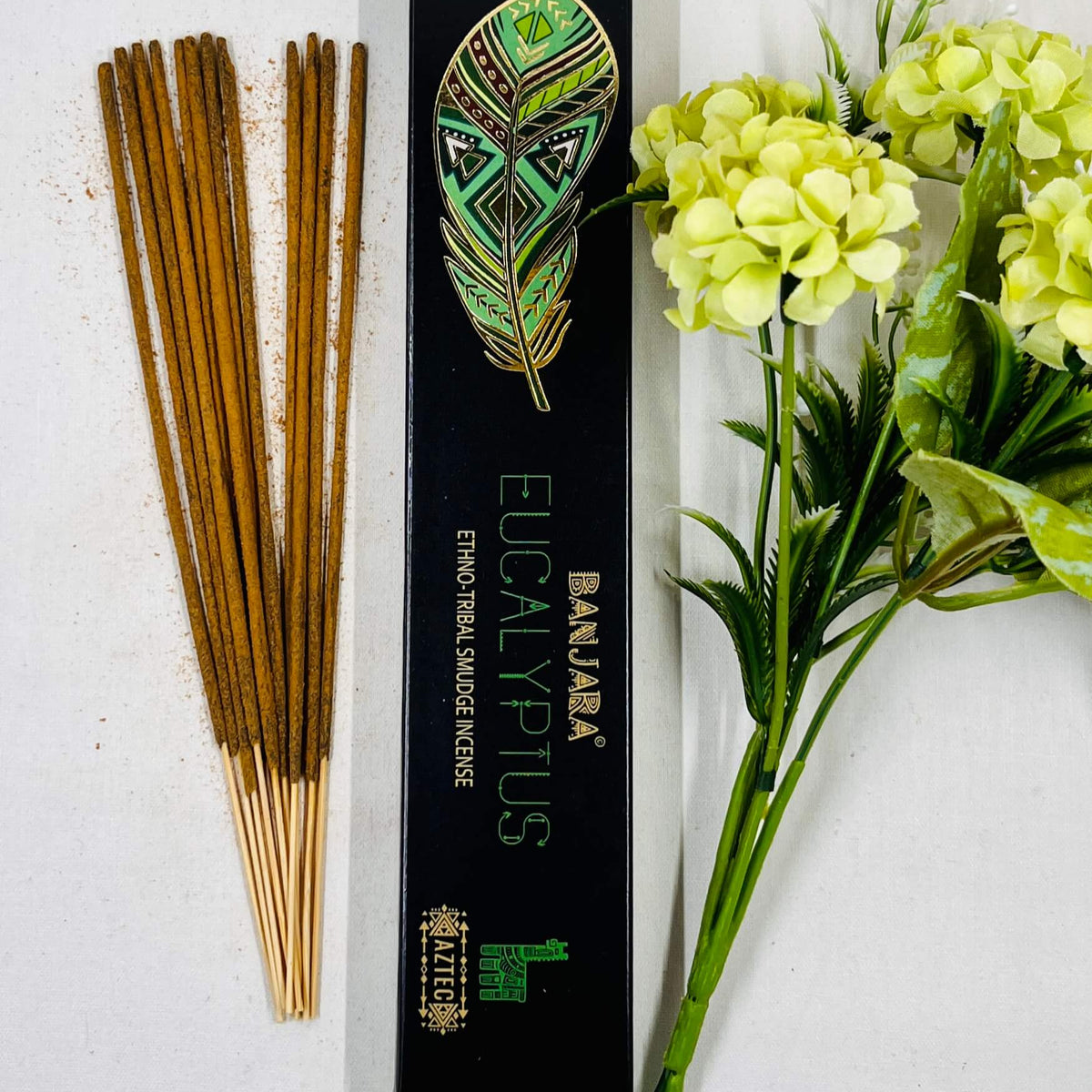 A packet of Banjara Aztec Eucalyptus incense sticks displayed alongside green and yellow floral decor.
