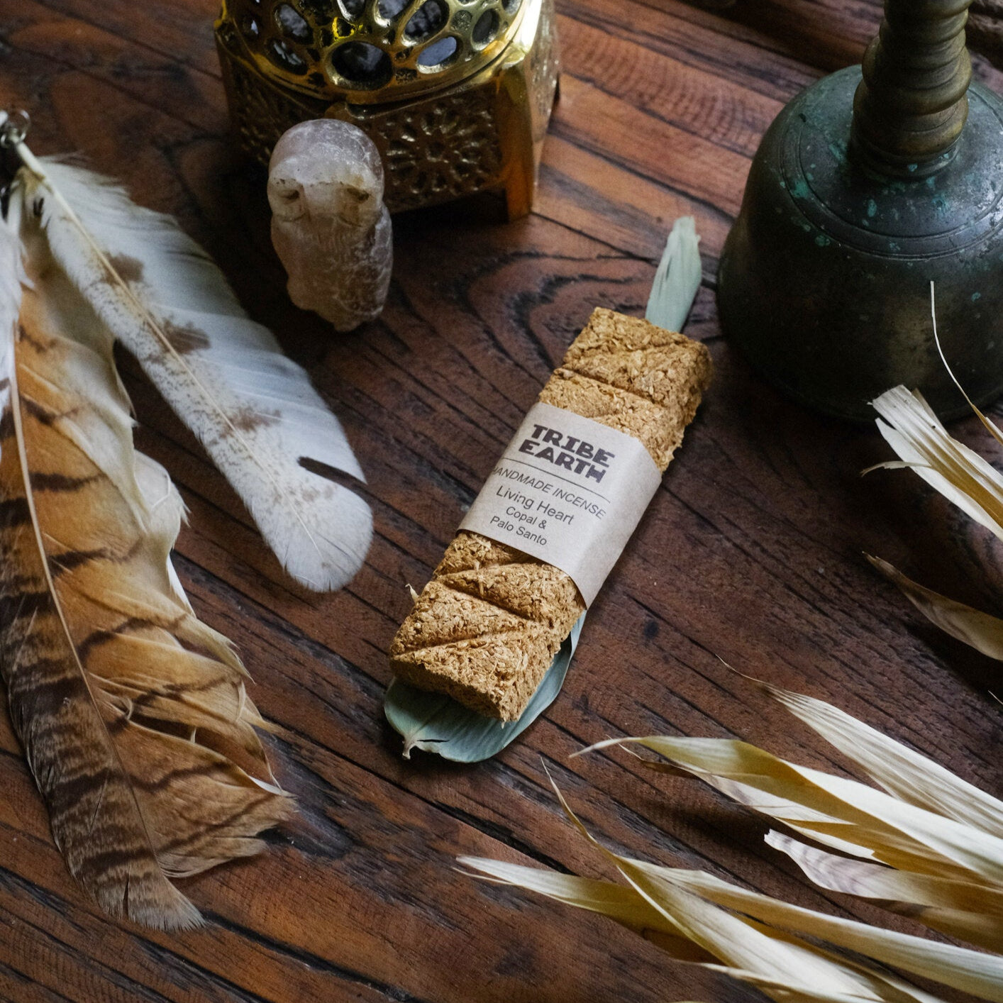 A photo featuring a handmade incense plank along with various items including what appears to be a Palo Santo wood piece, Copal resin, and other incense accessories placed on a wooden surface.