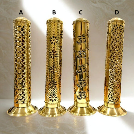Four gold cylindrical objects with intricate patterns on a marble surface