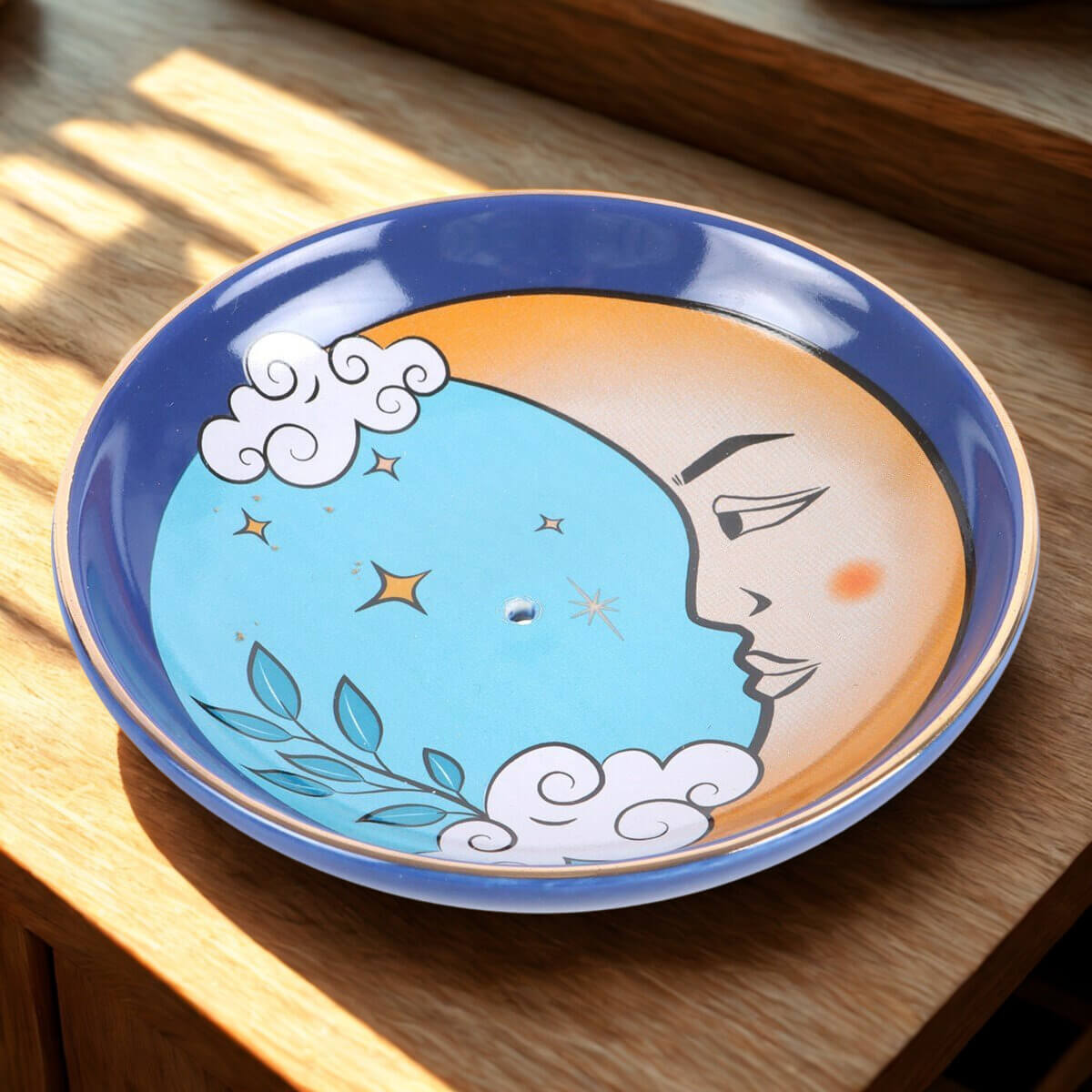 Ceramic plate with moon and cloud design on a wooden surface