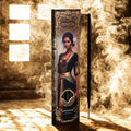 Perfume bottle with decorative packaging featuring a woman's portrait in a smoky, warm-toned setting.