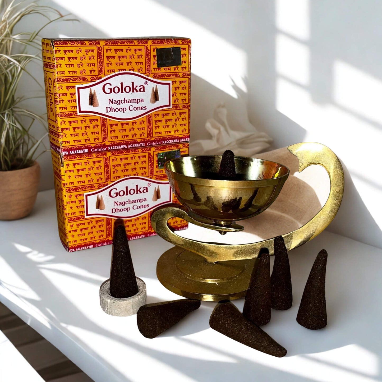 Goloka incense cones packaging with cones and a brass bowl on a white surface.