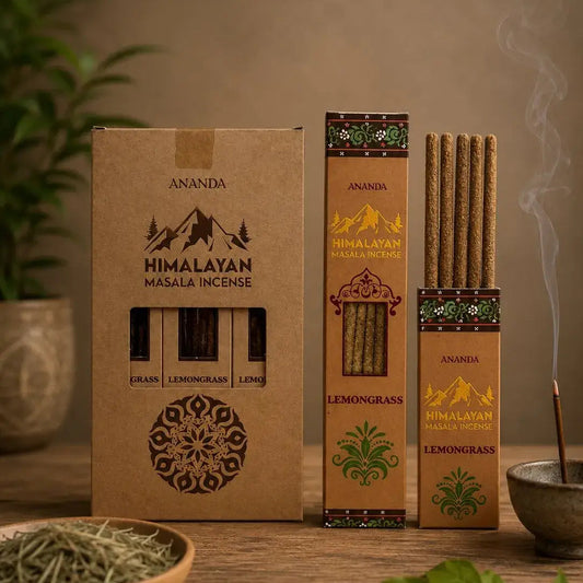 Three boxes of Ananda Himalayan Masala Incense on a wooden table, with one open box showing incense sticks, a bowl of dried herbs, and a smoking incense stick in a bowl, set against a warm neutral background.