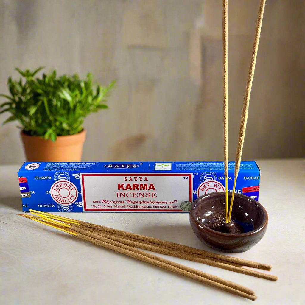 Sativa Karma incense packaging with incense sticks and a bowl on a textured surface.